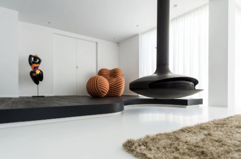 Minimalistisch wit interieur met hangende zwarte haard